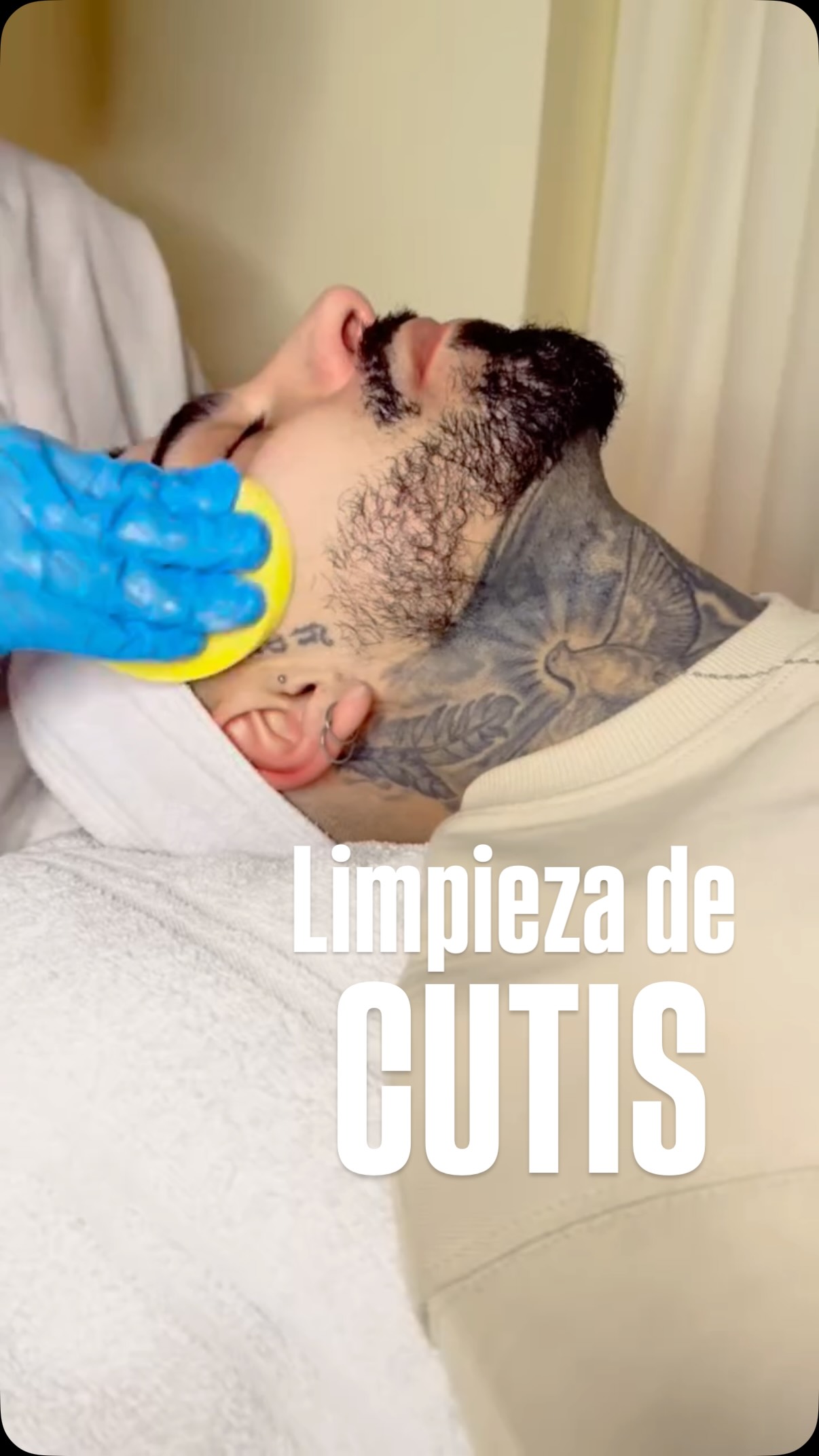 Limpieza de cutis en la cabina de Beauty Specialist: una esponja sobre el rostro de un cliente recostado en la camilla